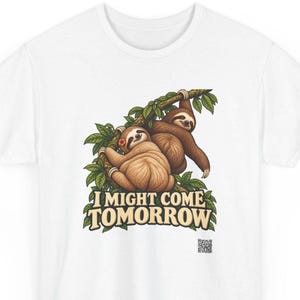 Pode incluir: Uma t-shirt branca com um gr&aacute;fico de duas pregui&ccedil;as castanhas penduradas num ramo de &aacute;rvore com folhas. Uma pregui&ccedil;a usa uma pequena flor cor de laranja. Abaixo das pregui&ccedil;as, o texto I MIGHT COME TOMORROW em letras claras com contorno.