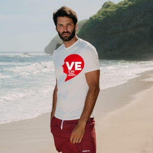 Puede incluir: Una camiseta blanca de manga corta con un gr&aacute;fico rojo en forma de coraz&oacute;n en el pecho con el texto VE R WE FULL HEART? y pantalones cortos granates con cord&oacute;n blanco y un peque&ntilde;o logotipo blanco en la pierna izquierda.