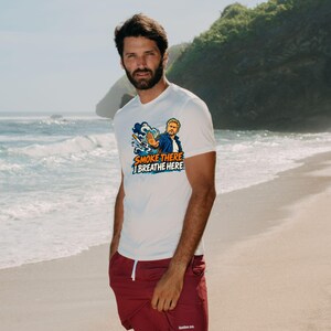 May include: A white short-sleeved t-shirt featuring a graphic of a person gesturing to stop a cigarette with the text SMOKE THERE I BREATHE HERE, paired with solid maroon shorts featuring a small white logo on the lower left leg.