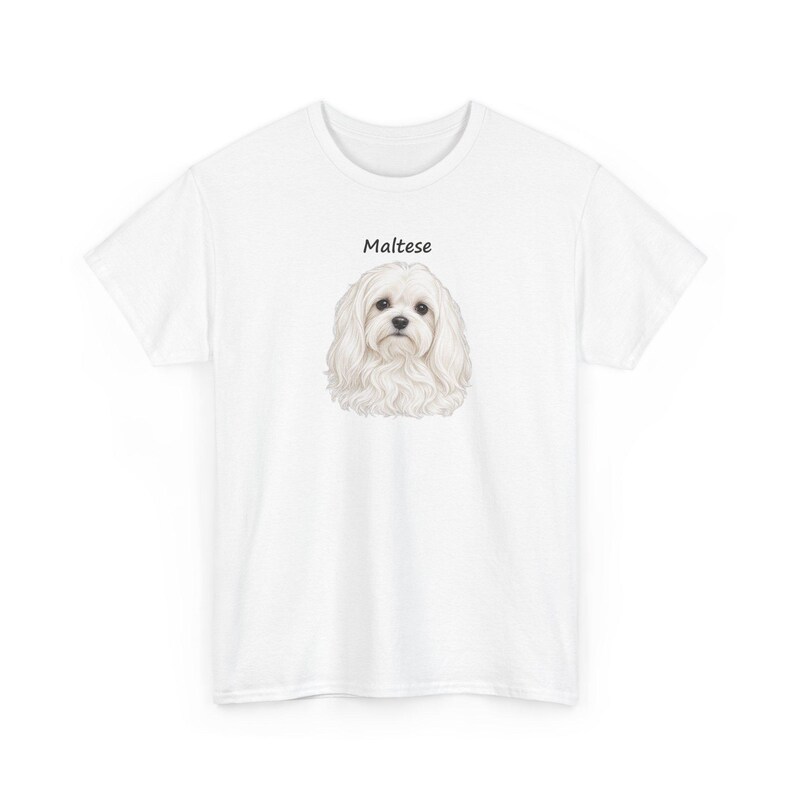 May include: A white short-sleeved t-shirt featuring a centered illustration of a fluffy white Maltese dog. Above the dog, the word Maltese is printed in a simple black sans-serif font. The shirt has a crew neckline and a standard fit.