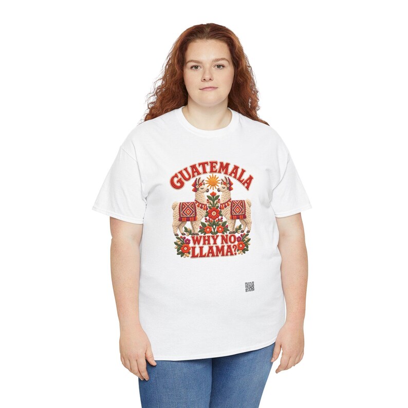 Puede incluir: Una camiseta blanca de manga corta con un gr&aacute;fico de dos llamas frente a frente, rodeadas de flores y un sol. El texto GUATEMALA WHY NO LLAMA? aparece en letras rojas. Un peque&ntilde;o c&oacute;digo QR cuadrado est&aacute; impreso bajo el dise&ntilde;o.