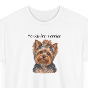 Op de afbeelding: Een wit t-shirt met een gedetailleerde illustratie van een Yorkshire Terri&euml;r met bruin en zwart haar, een klein staartje bovenop, en de tekst Yorkshire Terrier in zwarte letters boven de kop van de hond op de voorzijde.