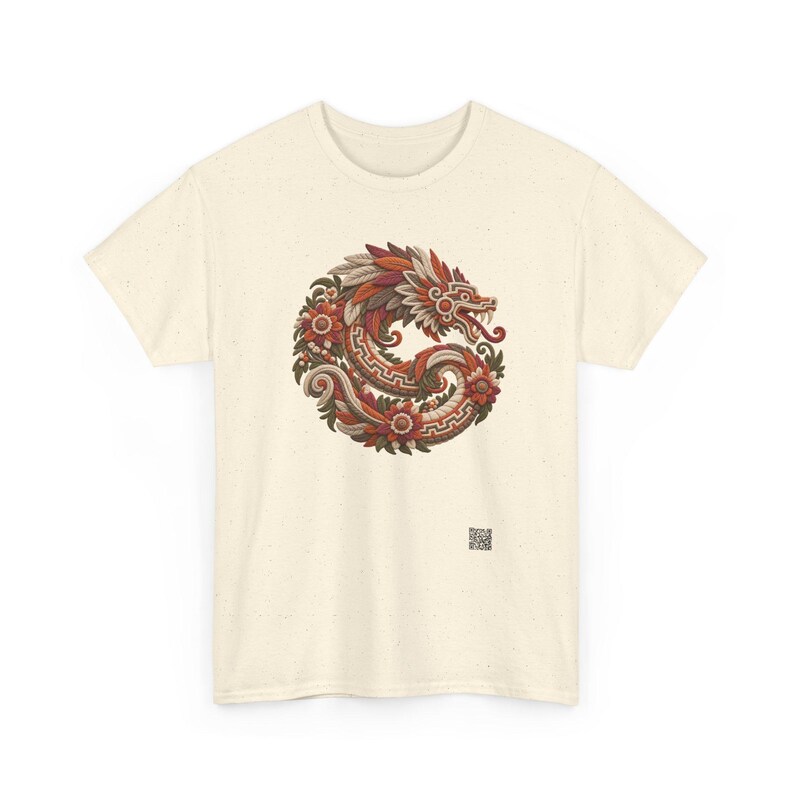 Puede incluir: Una camiseta de manga corta color crema con un gr&aacute;fico circular de una serpiente estilizada entrelazada con elementos florales en tonos rojos, naranjas, marrones y verdes. Un peque&ntilde;o c&oacute;digo QR cuadrado est&aacute; impreso cerca del dobladillo inferior derecho.