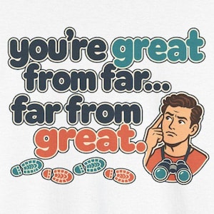 May include: A white t-shirt graphic featuring the text "you're great from far... far from great." in dark blue, teal, and orange. An illustration of a person with brown hair wearing binoculars and pointing to their head is included.