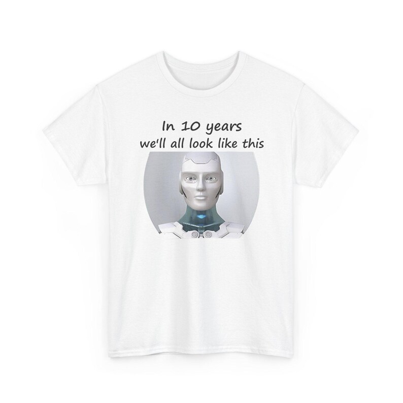 May include: A white short-sleeved t-shirt featuring a graphic of a silver and white humanoid robot head and shoulders. Above the robot, the text reads: In 10 years we'll all look like this. The design is centered on the chest of the garment.