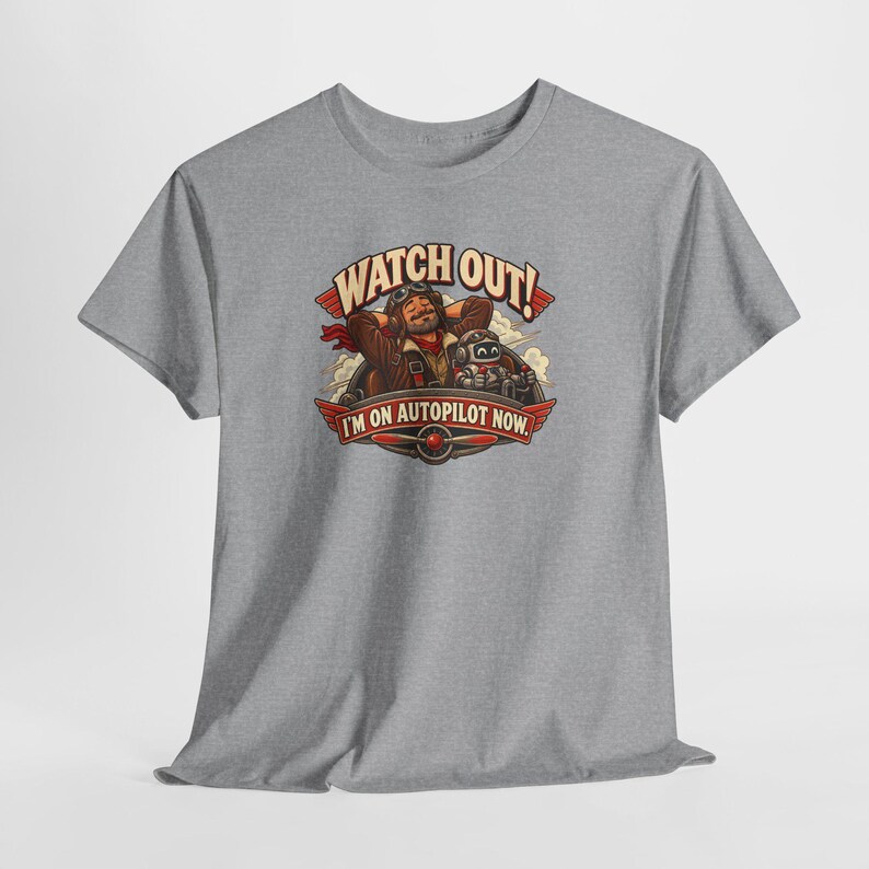 May include: A heather gray short-sleeve t-shirt featuring a graphic of a pilot and a small robot with the text WATCH OUT! I'M ON AUTOPILOT NOW. The design includes a propeller emblem and clouds in a vintage-inspired illustration style.
