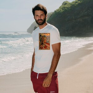 May include: A white short-sleeved t-shirt featuring a rectangular graphic print on the chest depicting a figure in an elaborate feathered headdress and traditional attire, paired with solid maroon athletic shorts with a white drawstring.