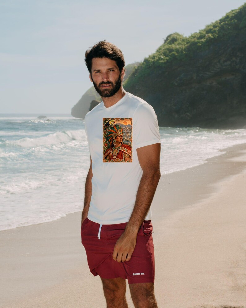 May include: A white short-sleeved t-shirt featuring a rectangular graphic print on the chest depicting a figure in an elaborate feathered headdress and traditional attire, paired with solid maroon athletic shorts with a white drawstring.