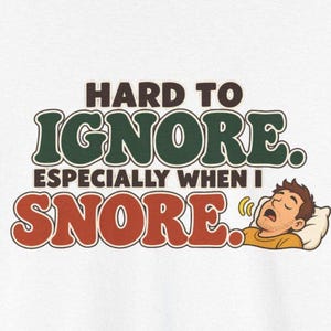 May include: A white t-shirt featuring the dark brown text HARD TO IGNORE. ESPECIALLY WHEN I SNORE. in a retro font. Next to the text is a cartoon illustration of a person with brown hair sleeping on a white pillow with yellow sound lines.