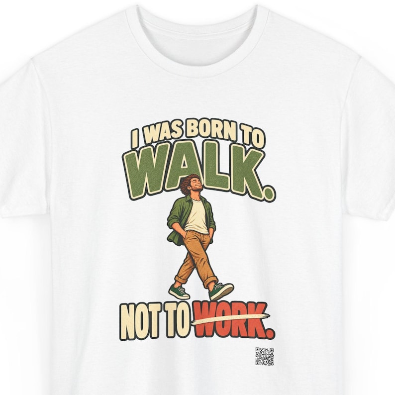 Op de afbeelding: Een wit t-shirt met een afbeelding van een lopend persoon met de handen in de zakken. De tekst luidt I WAS BORN TO WALK. NOT TO WORK. De persoon draagt een groen overhemd, een wit ondershirt en een bruine broek. Onderaan staat een QR-code.