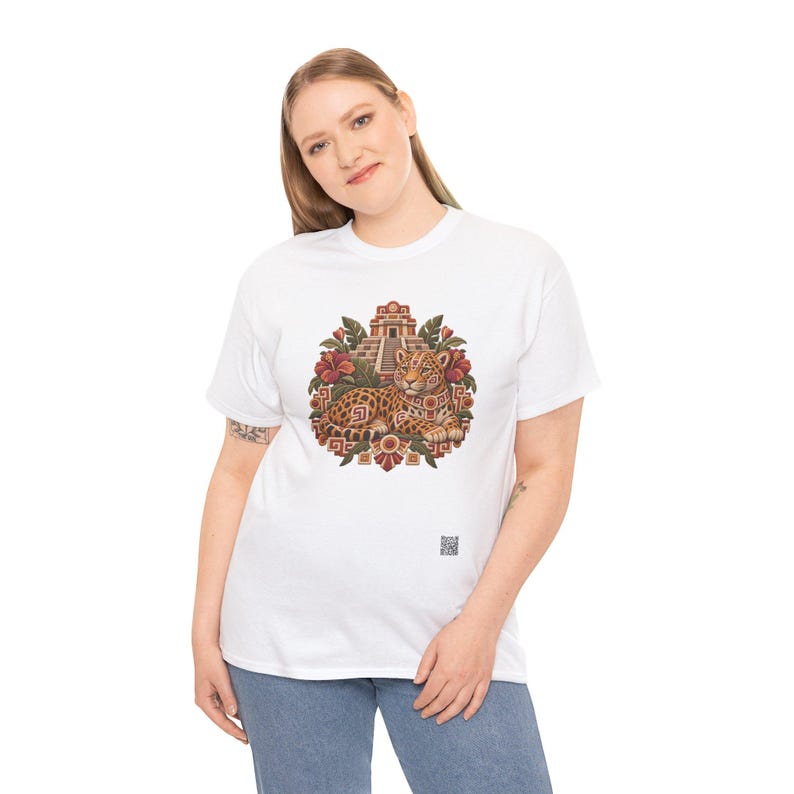 May include: A white short-sleeve t-shirt featuring a central graphic of a spotted jaguar resting in front of a stepped pyramid, surrounded by tropical leaves and red flowers, with a small square QR code printed near the bottom right.