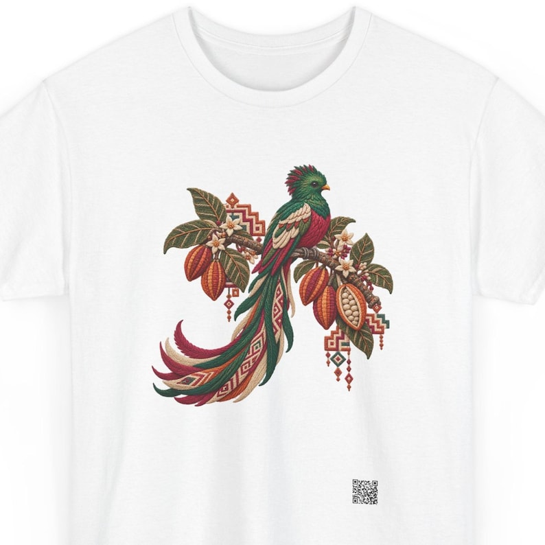 Resplendent quetzal shirt, Resplendent quetzal on a blooming cacao branch, front print of the t-shirt. A white t-shirt featuring a central graphic of a quetzal bird perched on a branch with cacao pods, green leaves, and white flowers.