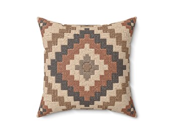 Könnte beinhalten: Ein quadratisches Zierkissen mit einem gewebten geometrischen Rautenmuster. Das Design besteht aus konzentrischen Schichten in Creme, Terrakotta, Dunkelgrau und Hellbraun, die ein sich wiederholendes Treppenmotiv auf der gesamten Oberfläche bilden.