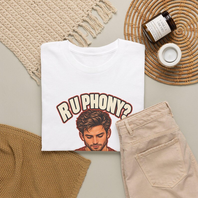 May include: A white short-sleeved t-shirt featuring a graphic of a person with dark hair looking downward. Above the illustration, the text RU PHONY? is printed in a bold, cream-colored font with a dark red outline on the chest area.