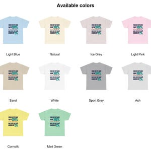 May include: A collection of ten short-sleeve t-shirts in light blue, natural, ice grey, light pink, sand, white, sport grey, ash, cornsilk, and mint green. Each shirt features the text: FROM 100 FEET AWAY, YOU'RE 100%... BABE, EVERY FOOT CLOSER KNOCKS OFF 1%.