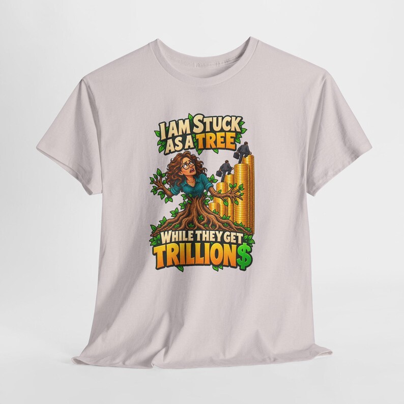 May include: A light gray t-shirt featuring a graphic of a person with brown hair and glasses emerging from a tree trunk. Beside them, two figures in suits climb stacks of gold coins. The text reads: I AM STUCK AS A TREE WHILE THEY GET TRILLION$.