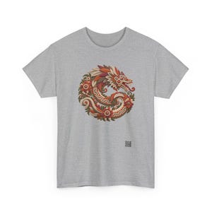 Puede incluir: Una camiseta de manga corta en gris jaspeado con un gr&aacute;fico circular de un drag&oacute;n enroscado entrelazado con elementos florales en tonos rojos, naranjas y crema. El dise&ntilde;o incluye patrones geom&eacute;tricos y un peque&ntilde;o c&oacute;digo QR cuadrado.