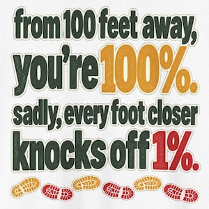 May include: A white graphic t-shirt featuring dark green text that reads: from 100 feet away, you're 100%. sadly, every foot closer knocks off 1%. The numbers 100% are in gold, 1% is in red, and there are small gold and red shoe print icons below.