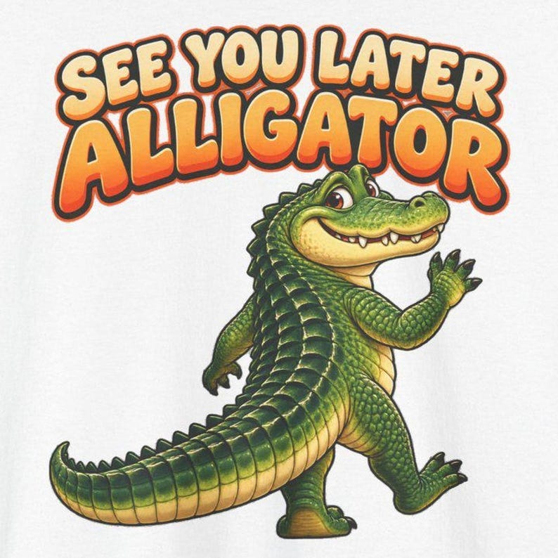 May include: A white t-shirt featuring a cartoon alligator with green scales and a light yellow underbelly. The alligator is waving its hand. Above the alligator, the text reads SEE YOU LATER ALLIGATOR in bold orange letters.