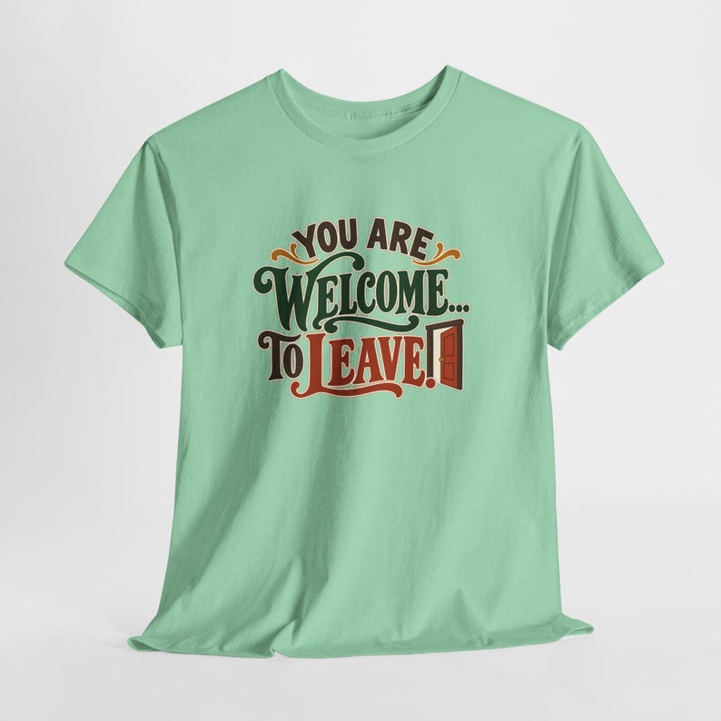 May include: A light mint green short-sleeve t-shirt featuring the dark brown and red text "YOU ARE WELCOME... TO LEAVE!" with a small graphic of an open door next to the word LEAVE, centered on the chest of the garment.
