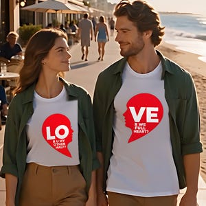 Couple walking on a beach promenade wearing matching LO and VE half heart shirts