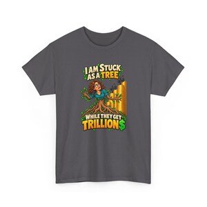 May include: A dark gray t-shirt featuring a graphic of a person with brown hair and glasses emerging from a tree trunk. Behind them are stacks of gold coins with small figures on top. The text reads: I AM STUCK AS A TREE WHILE THEY GET TRILLION$.