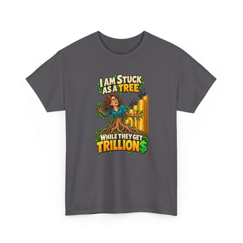May include: A dark gray t-shirt featuring a graphic of a person with brown hair and glasses emerging from a tree trunk. Behind them are stacks of gold coins with small figures on top. The text reads: I AM STUCK AS A TREE WHILE THEY GET TRILLION$.