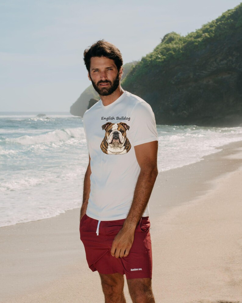 Puede incluir: Una camiseta blanca de manga corta con una ilustraci&oacute;n gr&aacute;fica de un bulldog ingl&eacute;s en el pecho y el texto "English Bulldog" impreso encima. La camiseta se combina con unos pantalones cortos de color granate liso con un cord&oacute;n blanco.