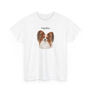 Puede incluir: Una camiseta blanca de manga corta con un gr&aacute;fico central de un perro Papillon marr&oacute;n y blanco. Sobre la cabeza del perro, la palabra Papillon est&aacute; impresa en una fuente negra sencilla sin remates. Tiene cuello redondo.