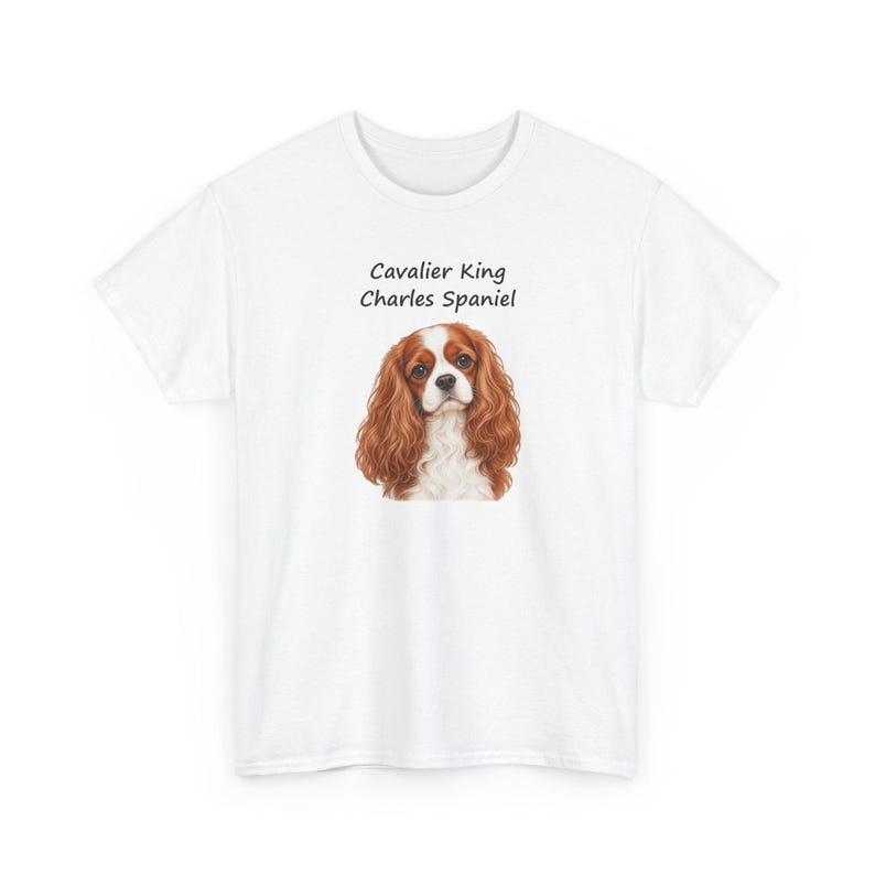 Puede incluir: Una camiseta blanca de manga corta con un gr&aacute;fico central de un perro Cavalier King Charles Spaniel marr&oacute;n y blanco. Sobre la ilustraci&oacute;n del perro, el texto dice Cavalier King Charles Spaniel en una fuente negra sencilla.