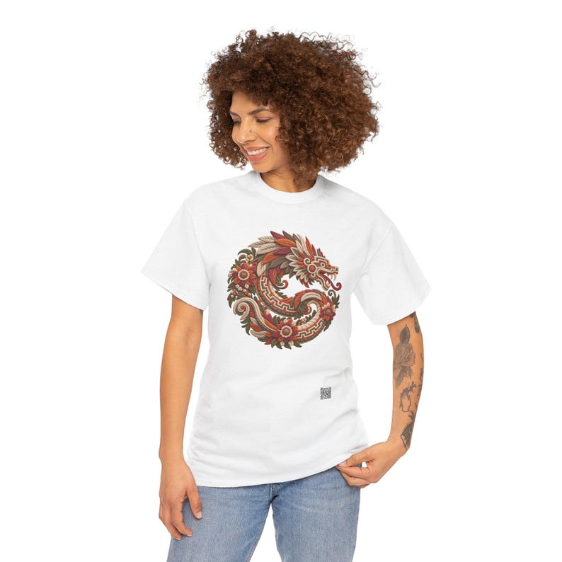 Puede incluir: Una camiseta blanca de manga corta con un gr&aacute;fico circular en el pecho. El dise&ntilde;o muestra un drag&oacute;n estilizado enroscado en un anillo, representado en tonos rojos, naranjas y marrones con intrincados patrones florales y bordes geom&eacute;tricos.