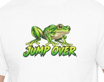 Puede incluir: Una camiseta blanca con un gráfico de una rana verde de ojos grandes situada sobre el texto JUMP OVER en una fuente verde estilizada. La rana aparece en posición agachada con las patas extendidas sobre la tela.