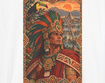 May include: A white t-shirt featuring a graphic print of a person wearing a large, colourful feathered headdress and a red cloak. The design includes a toucan, a sun setting over a landscape with ancient stone pyramids, and a decorative geometric border.