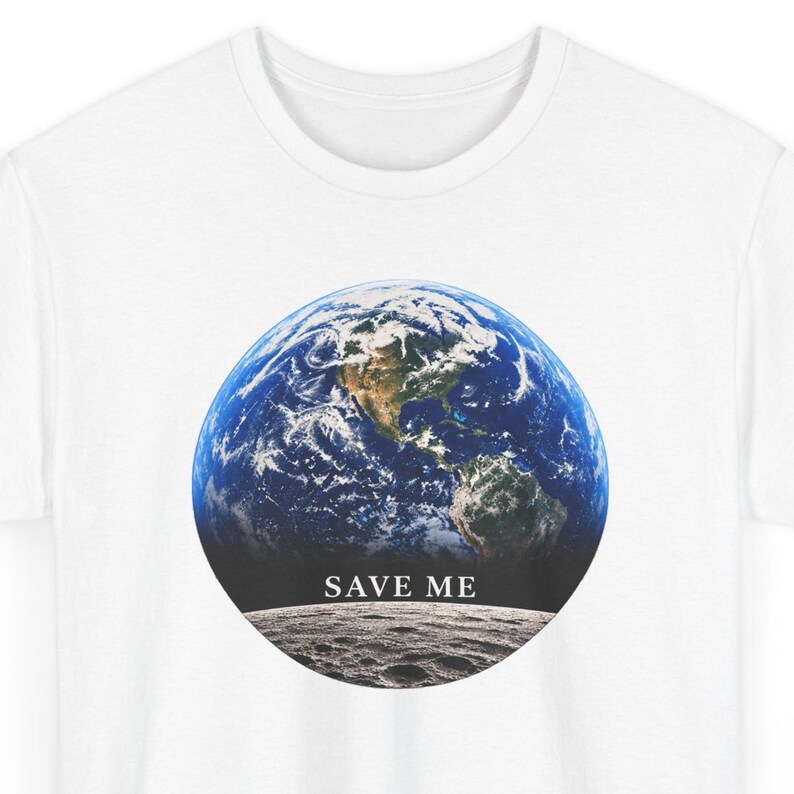 May include: A white t-shirt featuring a circular graphic of the Earth viewed from space, positioned above a gray lunar surface. The text "SAVE ME" is printed in a white serif font between the Earth and the moon's surface.