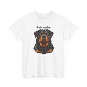 May include: A white short-sleeved t-shirt featuring a centered graphic illustration of a Rottweiler dog head with black and tan fur. Above the dog illustration, the word Rottweiler is printed in a simple black sans-serif font.
