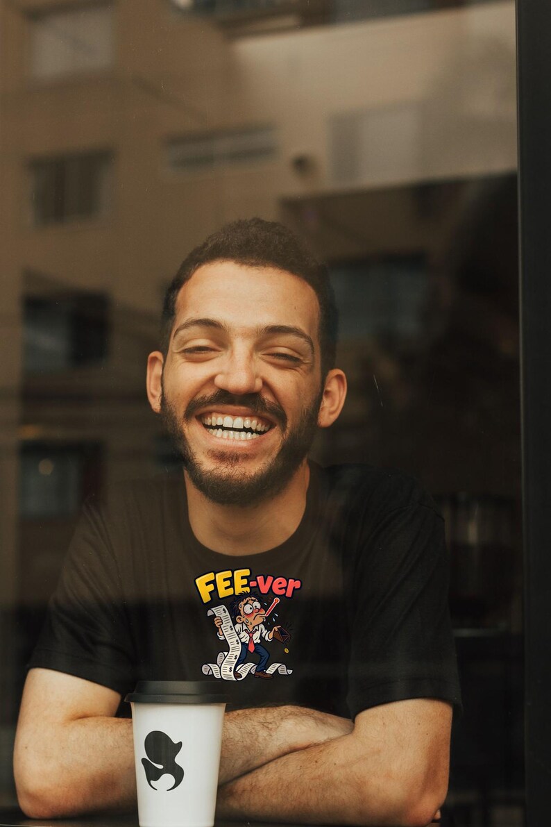 May include: A black short-sleeved t-shirt featuring a graphic print of a cartoon character with a thermometer in their mouth, holding a long receipt, with the yellow and red text "FEE-ver" printed above the illustration.