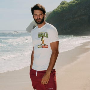 Op de afbeelding: Een wit T-shirt met korte mouwen en een afbeelding van een lopend persoon met de tekst I PREFER TO WALK NOT WORK, gecombineerd met een bordeauxrode short met een wit trekkoord en een klein wit logo op de linkerpijp.