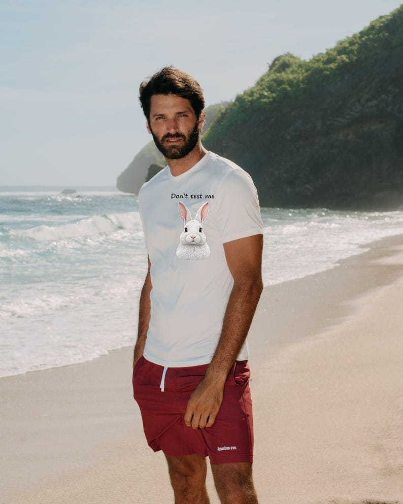 May include: A white short-sleeved t-shirt featuring a graphic of a white rabbit and the text "Don't test me" printed on the chest, paired with maroon shorts that have a white drawstring and a small white logo on the lower left leg.