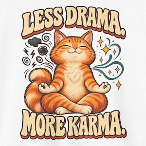 May include: A graphic print featuring an orange tabby cat sitting in a lotus meditation pose. The text above reads LESS DRAMA. and below reads MORE KARMA. To the left are dark swirling clouds and lightning bolts, while to the right are gold stars.