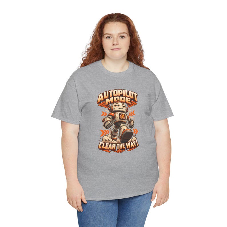 K&ouml;nnte beinhalten: Ein graues, kurz&auml;rmeliges T-Shirt mit einer Grafik eines laufenden Roboters in Orange und Wei&szlig;. Der Text &uuml;ber dem Roboter lautet AUTOPILOT MODE und der Text darunter lautet CLEAR THE WAY in einer fetten, orangefarbenen Schriftart.