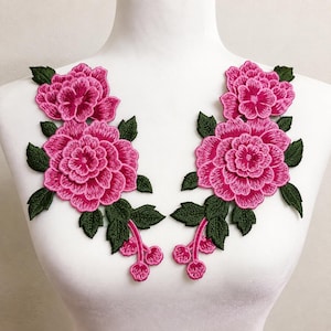 Puede incluir: Dos parches florales bordados simétricos que presentan flores de color rosa vibrante similares a peonías con pétalos en capas y hojas de color verde oscuro. Cada parche incluye un tallo con tres pequeños capullos rosas al final.