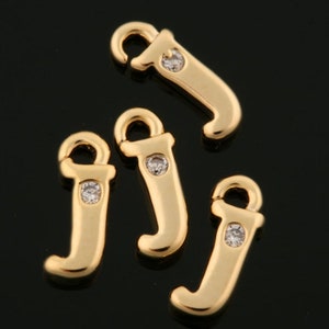 Puede incluir: Cuatro abalorios de la letra J en tono dorado con detalles de cristal transparente. Cada abalorio tiene un bucle en la parte superior para sujetarlo a joyas.