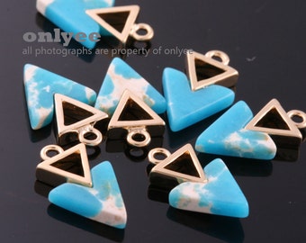May include: A group of turquoise and gold triangle shaped charms with a gold loop for hanging. The charms have a white marbled pattern.