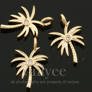 May include: Three gold palm tree charms with a clear rhinestone in the center of each tree. The charms have a detailed design and are perfect for jewelry making.