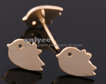 May include: A pair of gold-toned bird-shaped earrings. Each earring features a small hole in the center.