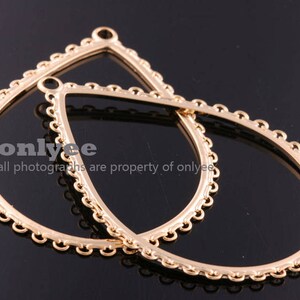 Puede incluir: Dos aros de metal dorado con un diseño de cadena decorativo. Los aros están unidos.