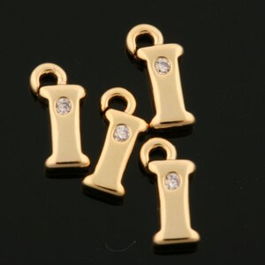 Puede incluir: Cuatro abalorios de la letra I en tono dorado con un strass transparente en el centro de cada letra. Los abalorios tienen un bucle en la parte superior para sujetarlos a un collar o pulsera.
