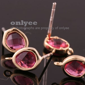 May include: Three pairs of gold-tone earrings with pink crystal stones. Each earring has a post back.
