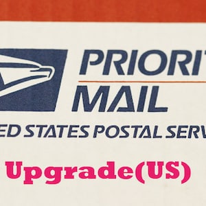 May include: A white label with the text "PRIORITY MAIL" and "UNITED STATES POSTAL SERVICE" in blue text. The USPS eagle logo is in the top left corner. The text "Upgrade(US)" is in pink text at the bottom of the label.