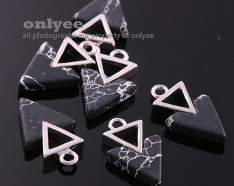 May include: A group of eight black and white triangle-shaped pendants with silver triangle frames. Each pendant has a silver loop at the top for hanging.